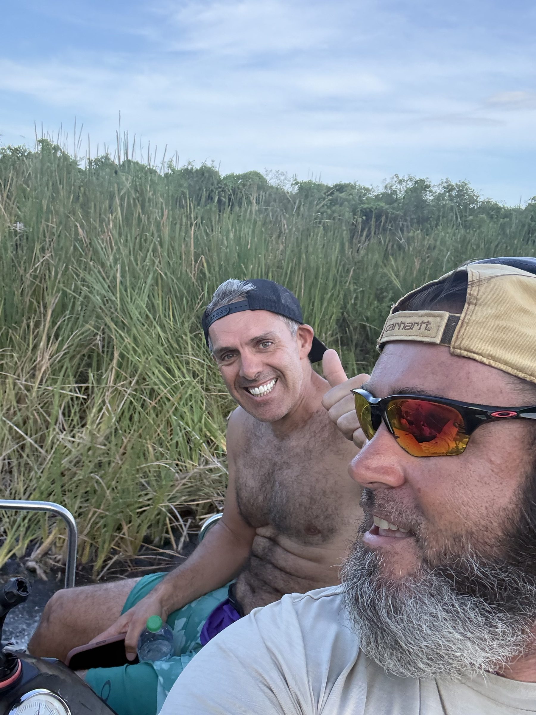 Two friends enjoying a fast airboat ride through the Everglades sawgrass