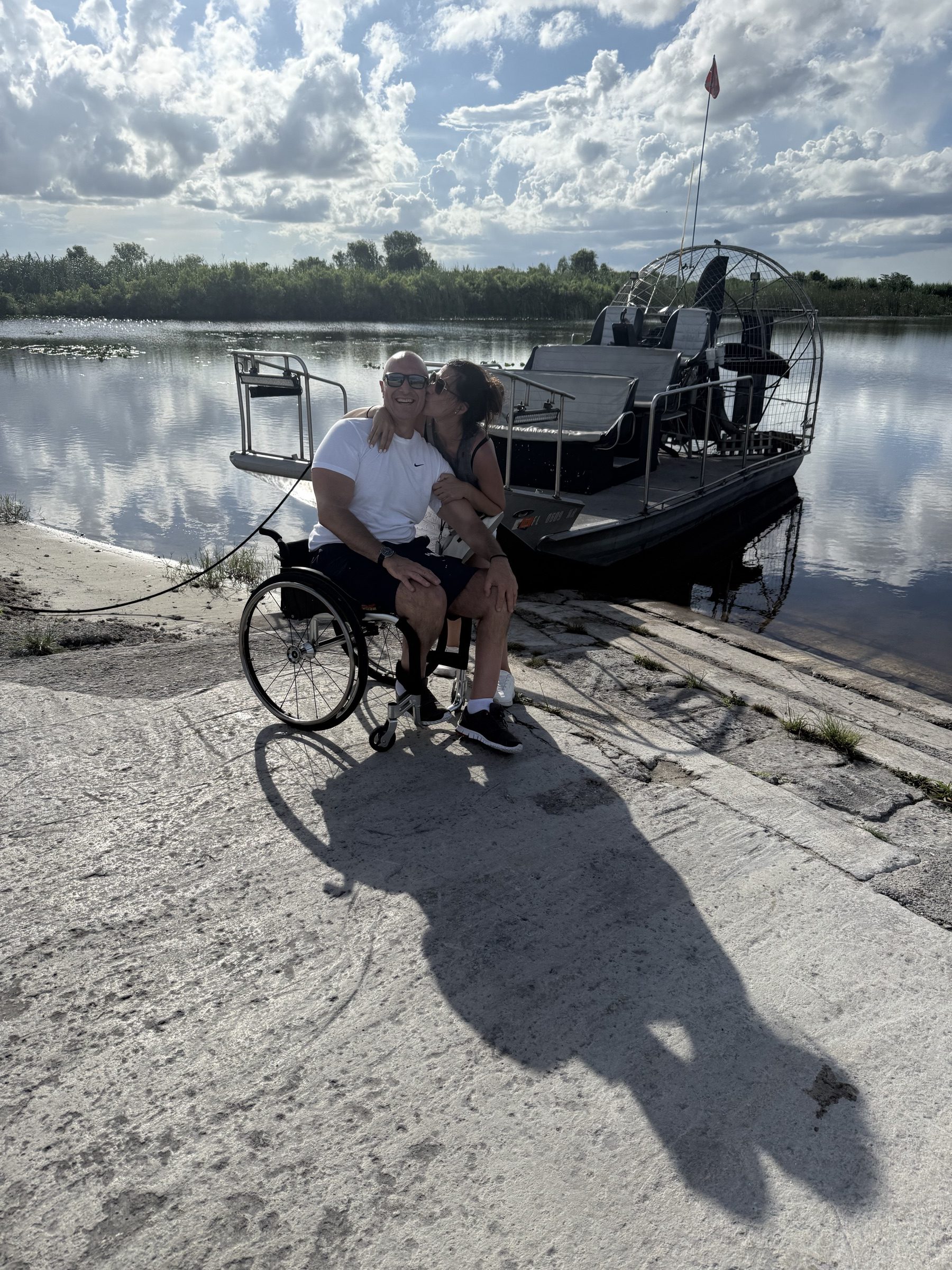 A guest using a wheelchair enjoying an accessible Everglades airboat tour with Aces Airboat Tours