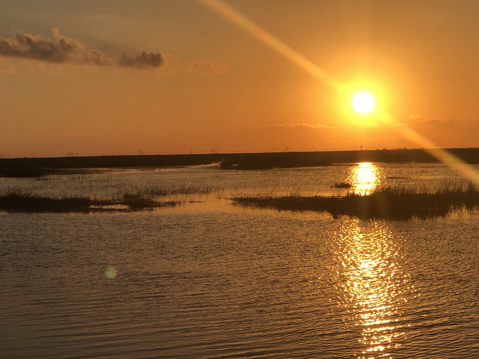 A blazing sunset over the open Everglades water on a sunset airboat tour