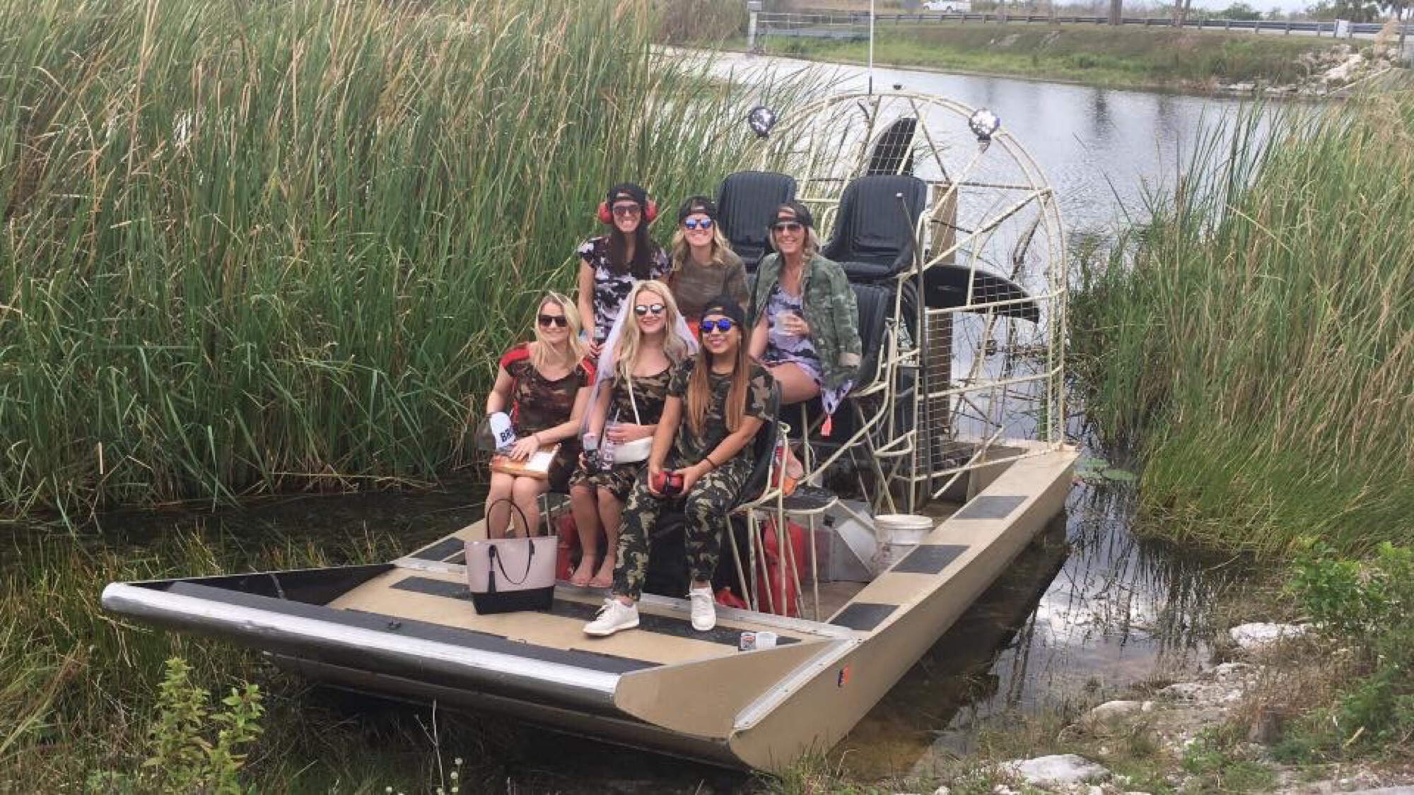 A large group enjoying an Aces Everglades airboat tour through the sawgrass