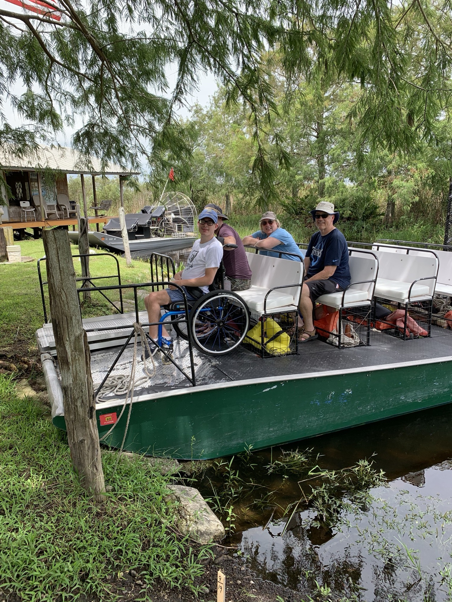 A wheelchair-using guest boarding an accessible Aces airboat at the dock