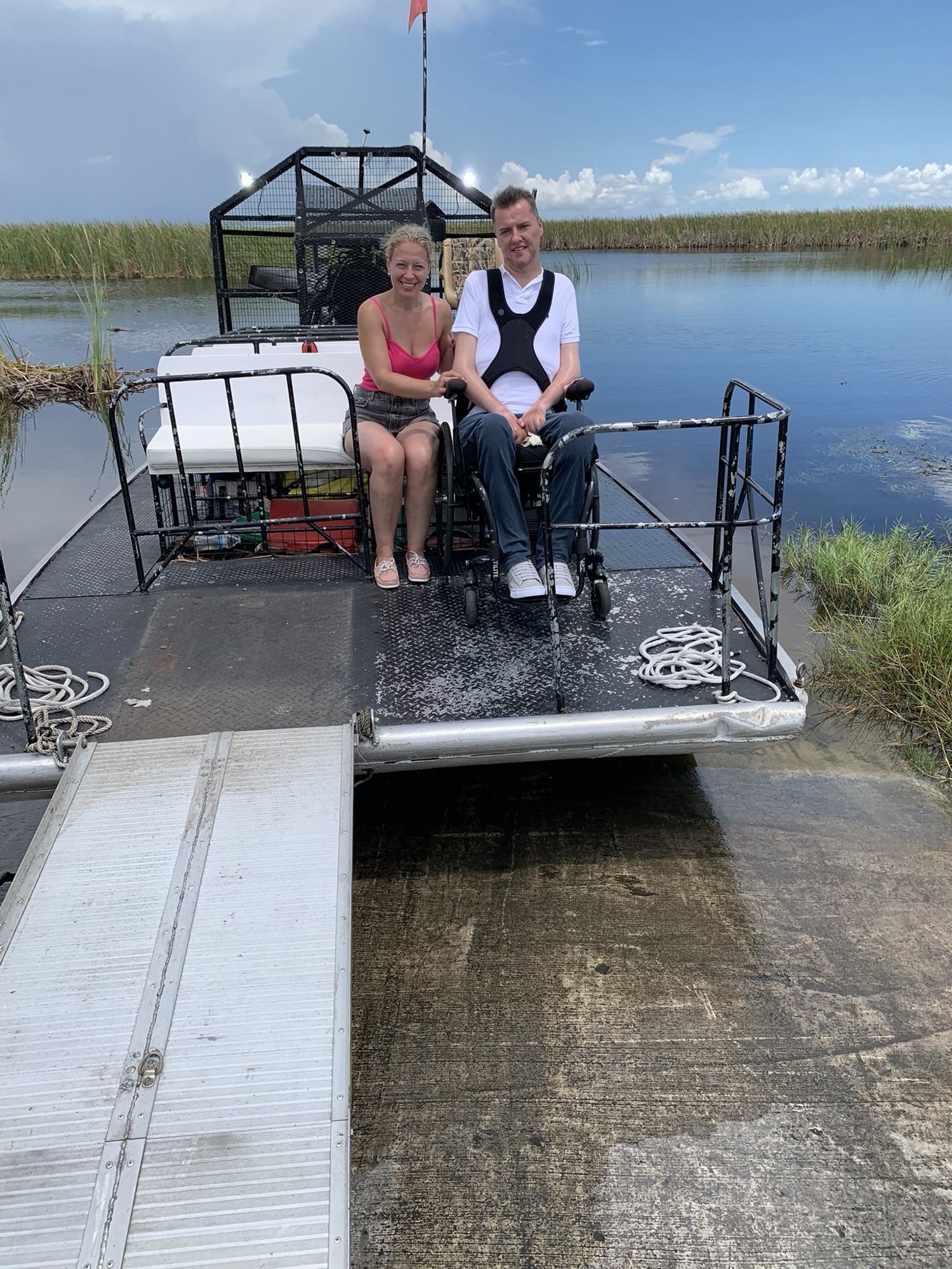 A guest boarding an Aces airboat via the wheelchair-accessible ramp