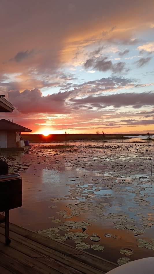 A fiery sunset over the dock and open water on an Everglades airboat tour